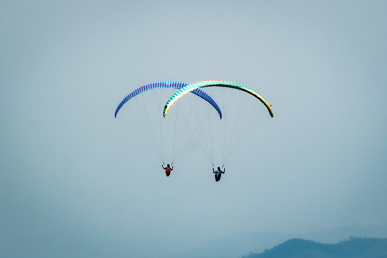 Crafting Captivating Headlines: Your awesome post title goes here Two paragliders soar through the misty skies over Sumedang, West Java, Indonesia.
